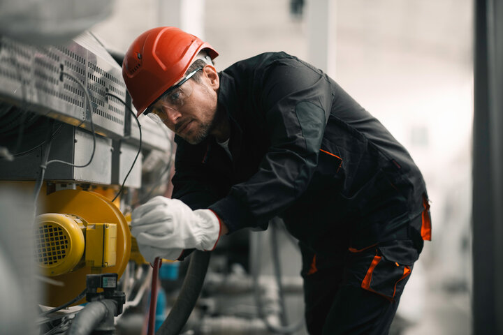 Construction worker using equipment wearing PPE
